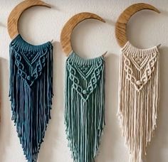 three wall hangings with different colors and designs on the wall next to each other