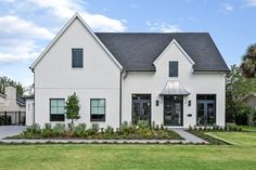 a large white house sitting on top of a lush green field