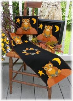 an owl themed table runner on a wooden chair with fall leaves and sunflowers