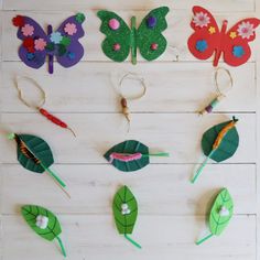 paper flowers and leaves are arranged on a wooden surface with scissors in the shape of butterflies