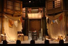 the stage is set up for a play with drapes hanging from the ceiling and curtains on the walls