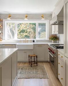 a kitchen with an oven, sink and stove top oven next to a large window