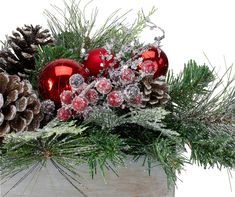 a wooden box filled with christmas decorations and pine cones on top of snow covered branches