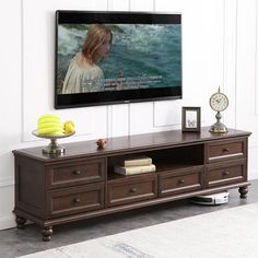 a flat screen tv mounted to the side of a wooden entertainment center in a living room