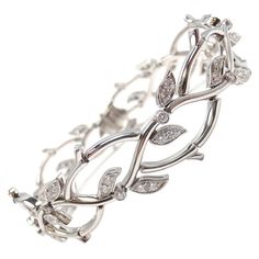 a silver bracelet with leaves and diamonds on it