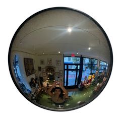 a woman is taking a selfie in the reflection of a fisheye lens mirror