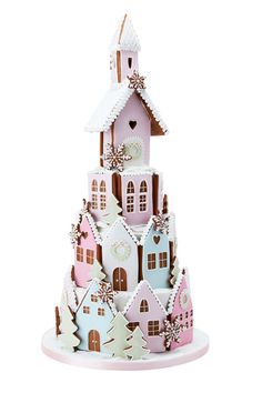 a christmas tree made out of gingerbread and icing with houses on top, decorated with snowflakes