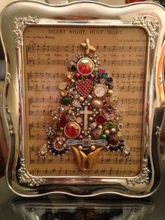 a christmas tree made out of buttons and other items on top of a sheet of music