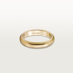 a yellow gold wedding ring with the word,'cartier'written on it