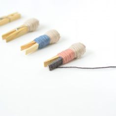 four skewers are lined up on a white surface and one has a string attached to it