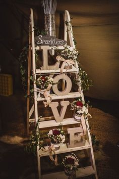 a wooden ladder decorated with flowers and greenery