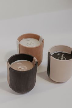 three different colored cups sitting next to each other on top of a white countertop