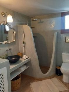 a bathroom with a sink, toilet and shower stall in the corner next to a window