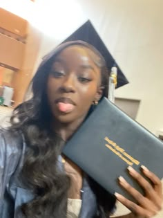 a woman in a graduation cap and gown holding a book