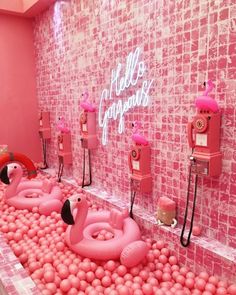 pink flamingo themed bathroom with bubble balls and telephones in the bathtub area