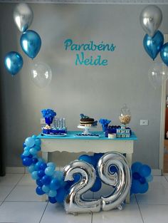 a table with balloons, cake and decorations for a 21st birthday party in blue and silver