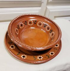 two brown bowls sitting on top of each other