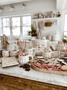 a kitchen counter topped with coffee cups and cookies