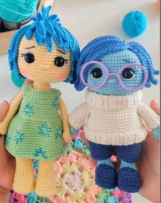 two crocheted dolls are standing next to each other