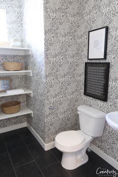 a white toilet sitting in a bathroom next to a wall mounted shelf filled with baskets