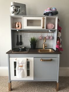 a toy kitchen with a sink and microwave