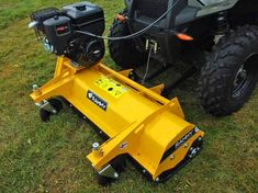 a yellow snow plow sitting in the grass