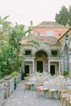 an outdoor dining area with tables and chairs set up for a formal function in front of a building