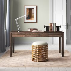 a wooden desk with a white stool in front of it and books on the table