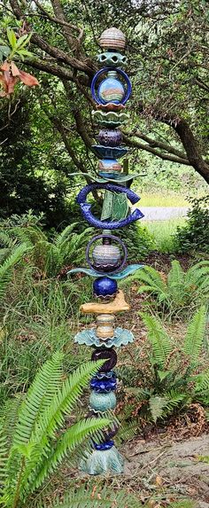 a tall glass sculpture sitting in the middle of a forest