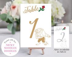 a table number card with a lion on it and flowers in the backgroud