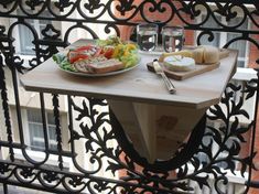 a plate of food sitting on top of a wooden table next to a metal fence