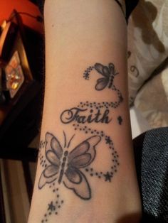 a woman's wrist tattoo with butterflies and the word faith written on her arm