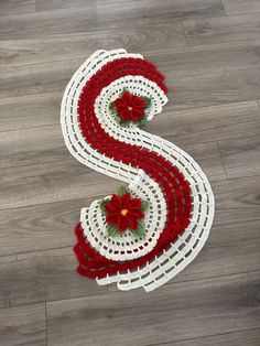 a red and white crocheted table runner with poinsettis