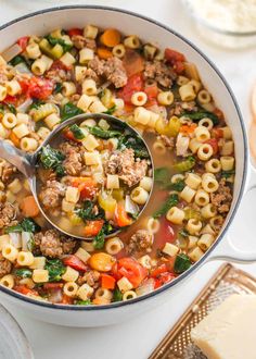 a ladle full of pasta and sausage soup