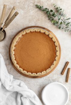 there is a pie on the table next to some utensils