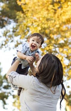 a woman holding a baby up in the air