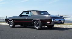 a black muscle car parked on the side of the road