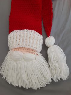 a crocheted santa hat with two white tassels