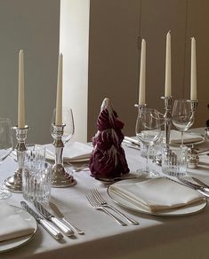 a table set with silverware and candles