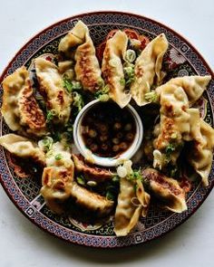 a plate filled with dumplings and dipping sauce