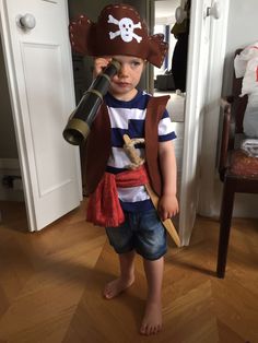 a little boy dressed as a pirate with a telescope