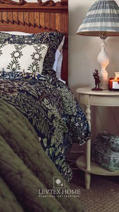 a bedroom with a bed, night stand and lamp on the nightstand next to it