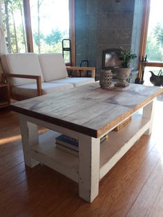 a wooden table sitting on top of a hard wood floor next to a white couch