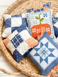 four decorative pillows sitting on top of a woven basket