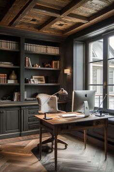 A cozy home office with dark wood shelves, a computer on a wooden desk, and a large window allowing natural light in. Small Home Office Library Ideas, Dark Grey Office Ideas, Office And Book Room, Cozy Home Office Library, Grey Office Ideas, Home Office Library Ideas, Cozy Home Office Ideas, Home Office Decor Inspiration, Witchy Office