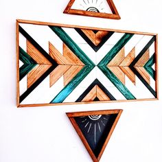 two pieces of art made out of wood with different shapes and sizes on the wall