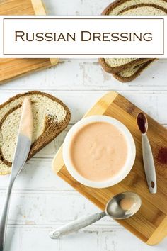 a wooden cutting board topped with slices of bread and a bowl of soup