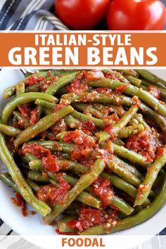 green beans with tomato sauce in a white bowl on top of a striped table cloth