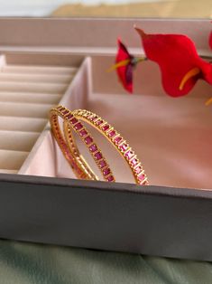 Set of 2 Bangles Ruby Color cz stone gold finish. Yellow Gold Plated Bangle For Celebration, Gold Gemstone Bangle For Festivals, Gold Bangle With Gemstone For Festivals, Gold Gemstone Bangle For Anniversary, Elegant Gold Bangle With Ruby, Gold Jeweled Bangle For Diwali, Hand Set Yellow Gold Bangle For Celebration, Hand Set Ruby Bracelets In Gold, Festive Gold Bangle With Stone Setting