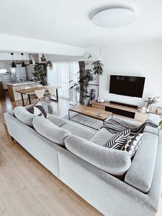 a living room filled with furniture and a flat screen tv on top of a wooden floor